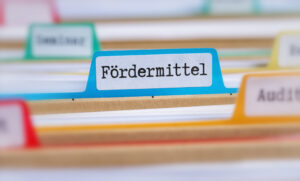 Mappen, dazwischen ein Schild mit dem Wort „Fördermittel”.